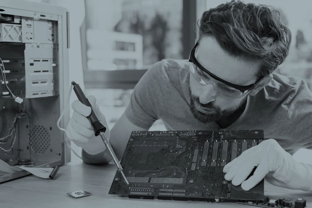 PC motherboard being serviced with a screwdriver on the bench